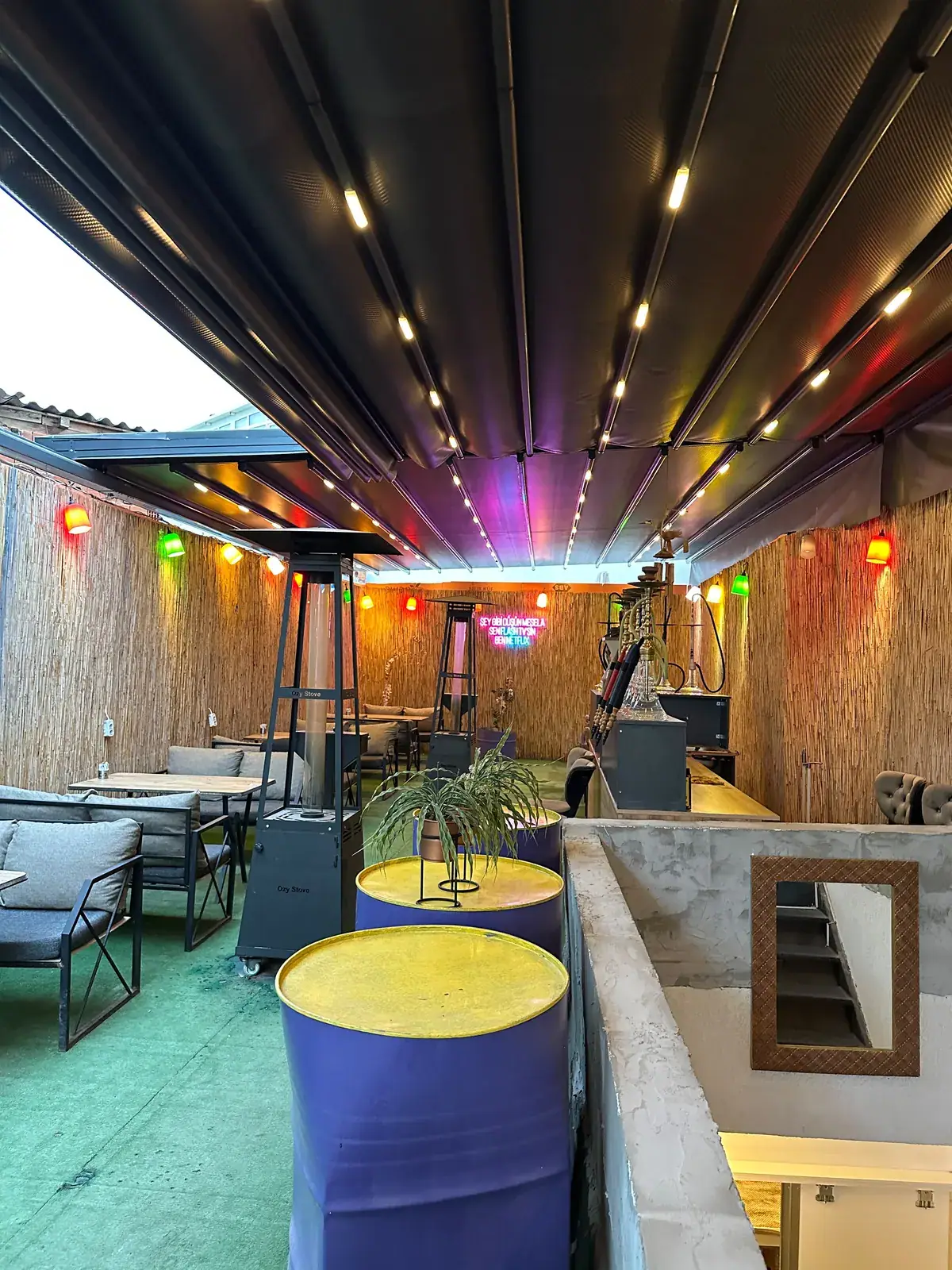 Renkli aydınlatmalı bar ve lounge alanında pergola tente tavan