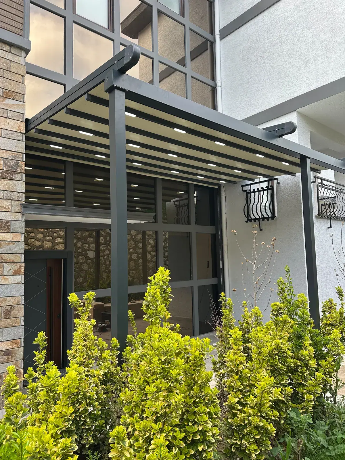 Bina girişine kurulan antrasit renk pergola sistemi