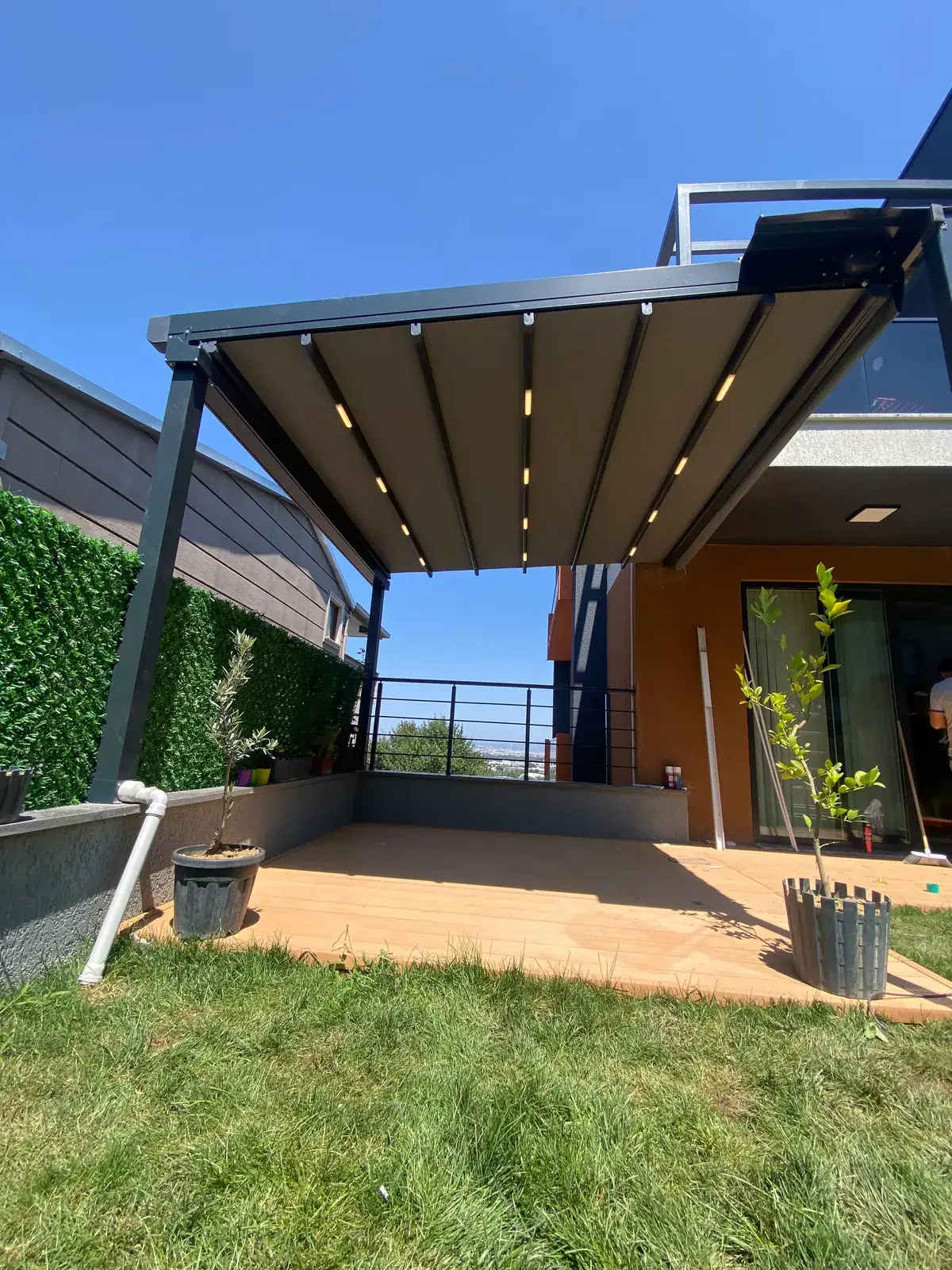 Villa bahçesinde çim alan üzerine kurulan antrasit pergola tente